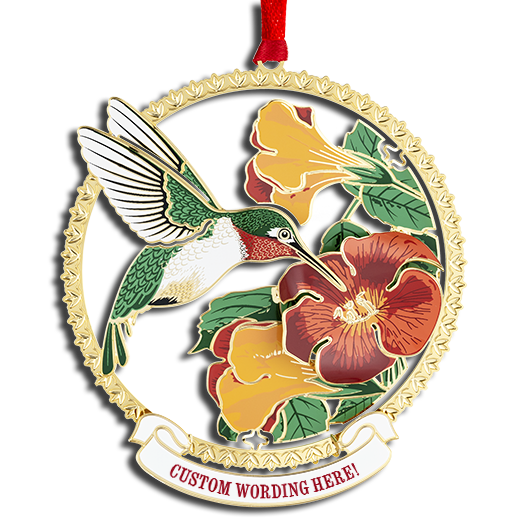 Circular brass-framed ornament with green hummingbird feeding on orange and yellow flowers. White banner at bottom reads “CUSTOM WORDING HERE!” in red.