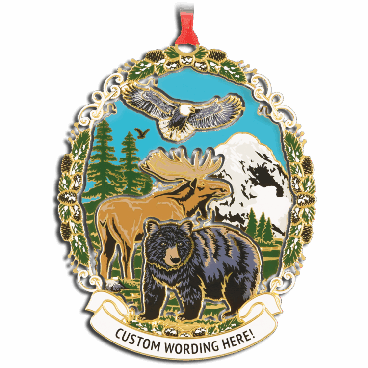 Colourful ornament featuring a moose, bear and eagle with green trees and a white mountain in the background. White banner at bottom reads “CUSTOM WORDING HERE!” in black.