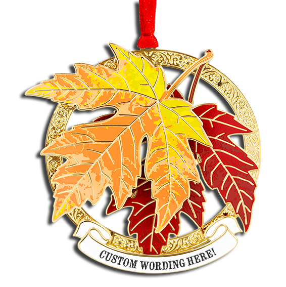 Ornament of two maple leaves, one orange, one red, sitting on top of a thick circular brass frame. White banner at the bottom reads “CUSTOM WORDING HERE!” in black.