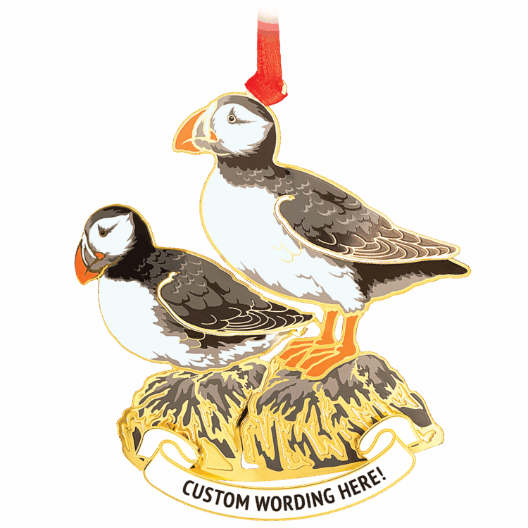 Ornament of two black, white and orange puffins on top of a grey and brass rock. White banner at the bottom reads “CUSTOM WORDING HERE!” in black.